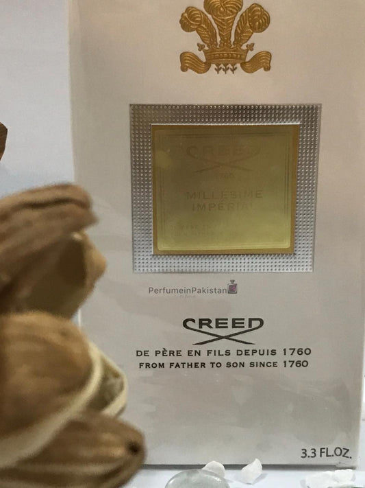 Creed Millésime Impérial Eau de Parfum 100ml perfume box displayed with decorative dried flowers and PerfumeinPakistan branding, featuring elegant white and gold packaging.