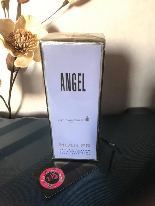 Mugler Angel Eau de Parfum Refillable Star 100ml perfume box displayed on a dark surface with decorative flowers and Perfume in Pakistan branding