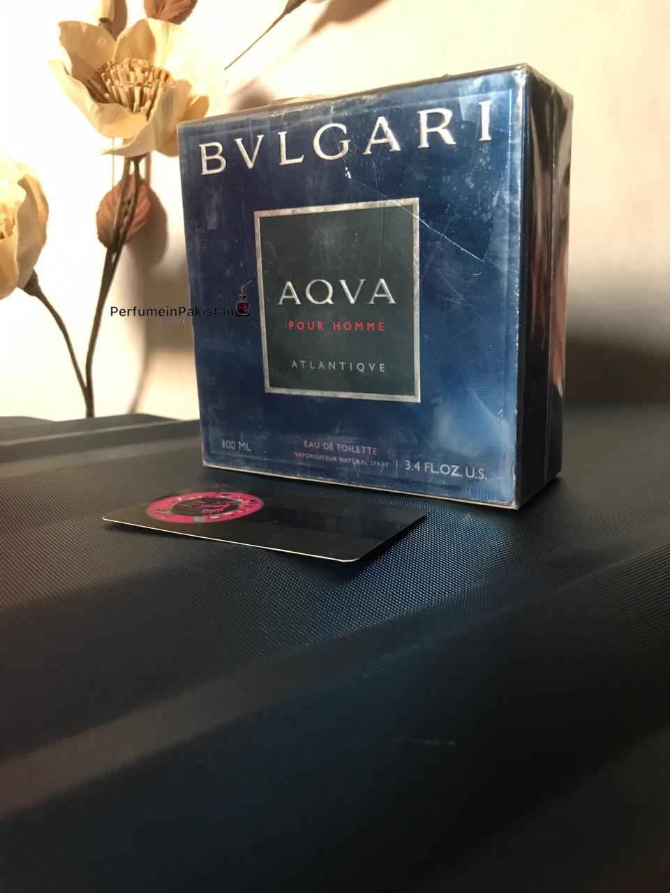 Bvlgari Aqva Pour Homme Atlantique EDT 100ml men's perfume box displayed on a dark surface with decorative flowers and Perfume in Pakistan branding