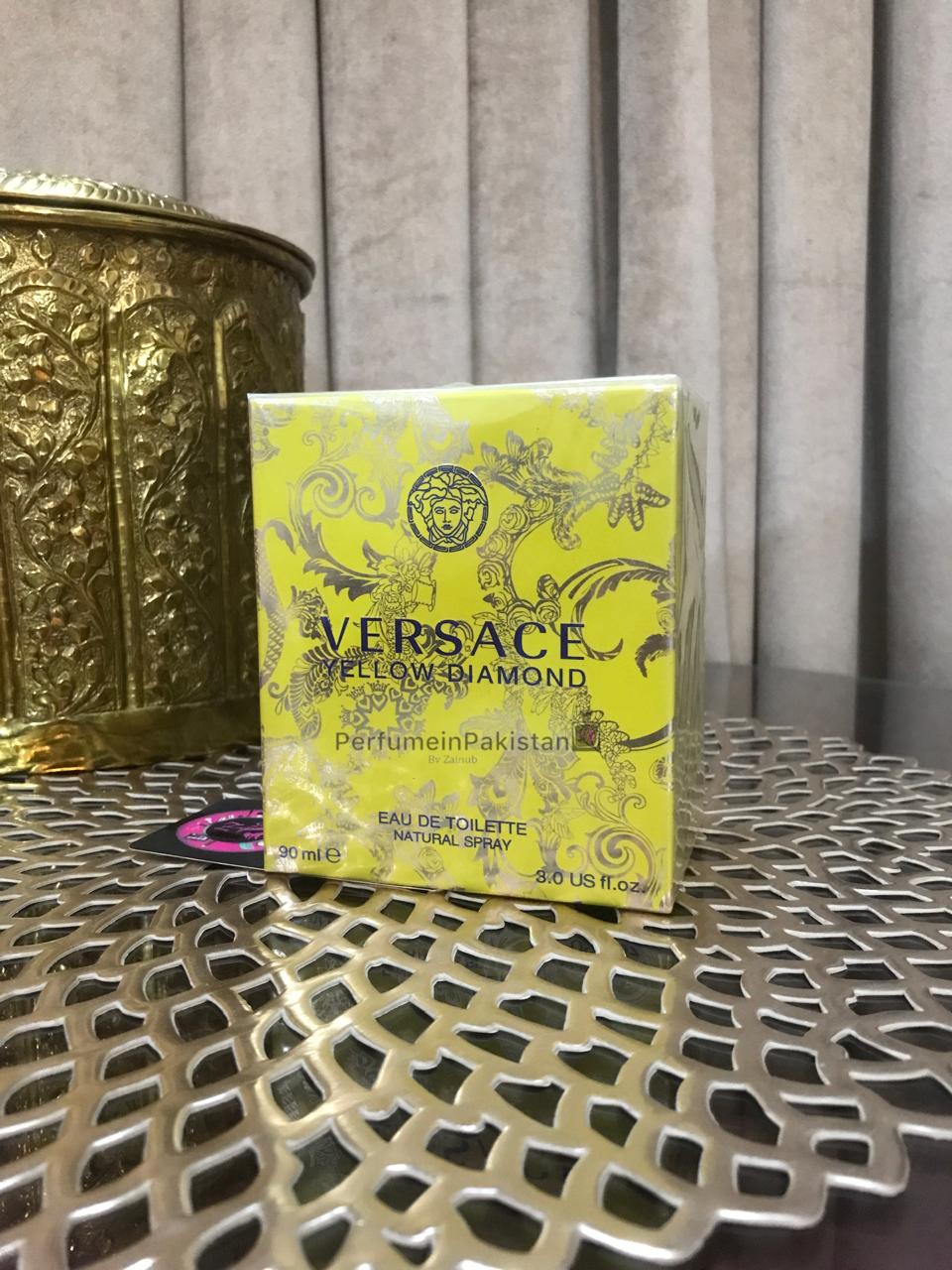 Versace Yellow Diamond Eau de Toilette 90ml perfume box displayed on decorative metallic table with Perfume in Pakistan branding
