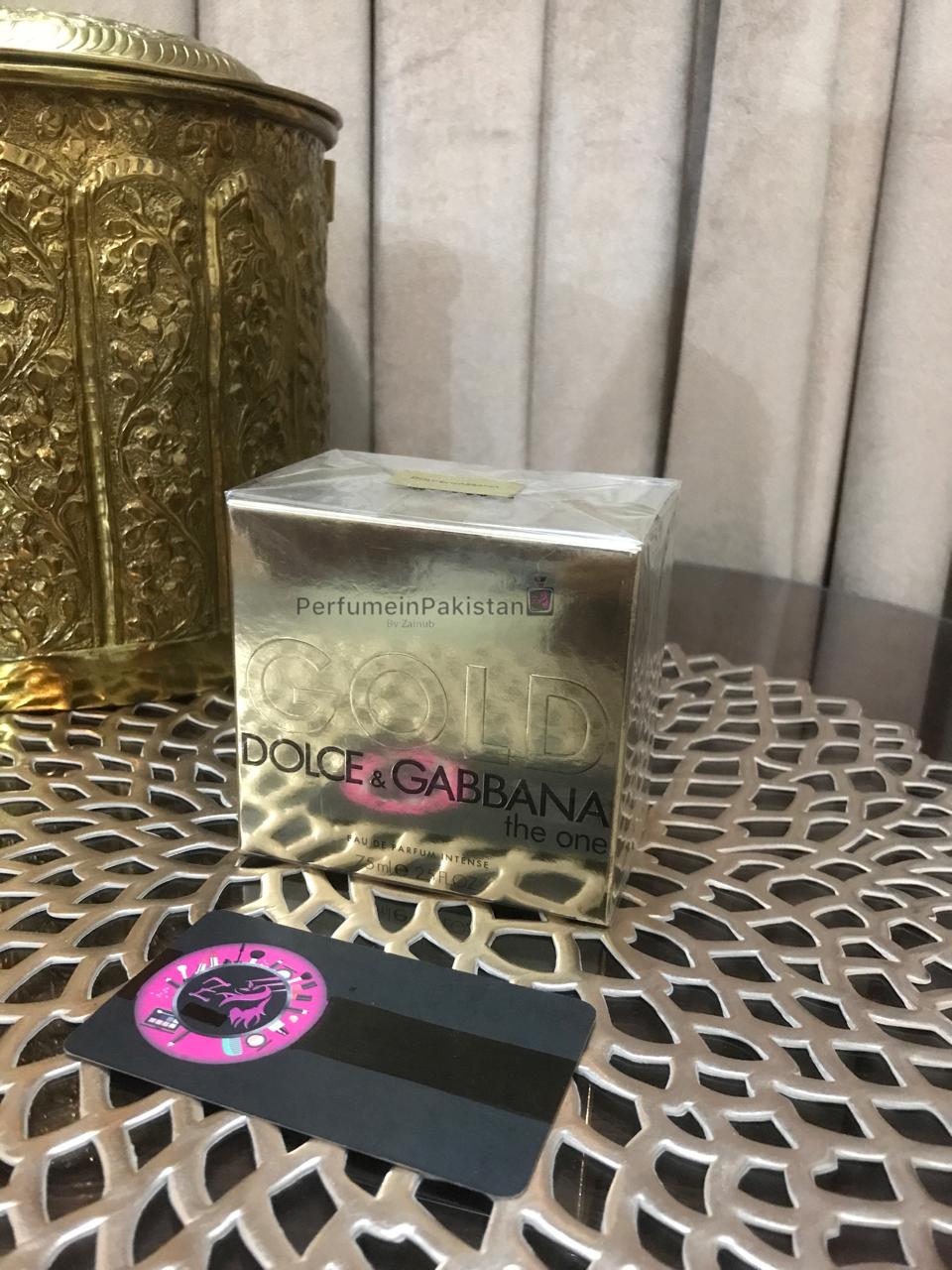 Dolce & Gabbana The One Gold Eau de Parfum Intense perfume box displayed on decorative metallic table with Perfume in Pakistan branding card