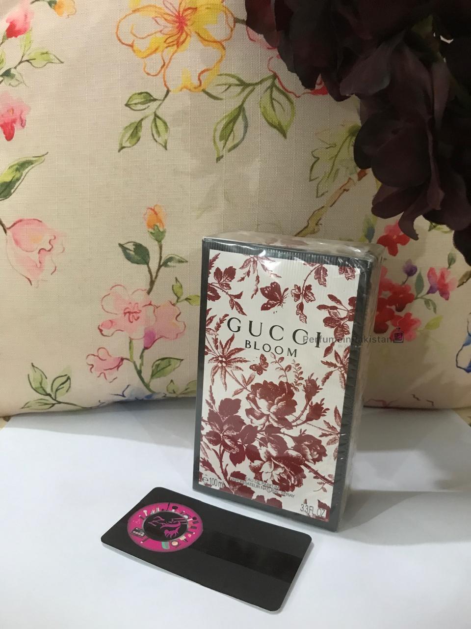 Gucci Bloom Eau de Parfum 100ml perfume box with floral artwork displayed against a floral background with PerfumeinPakistan branding card