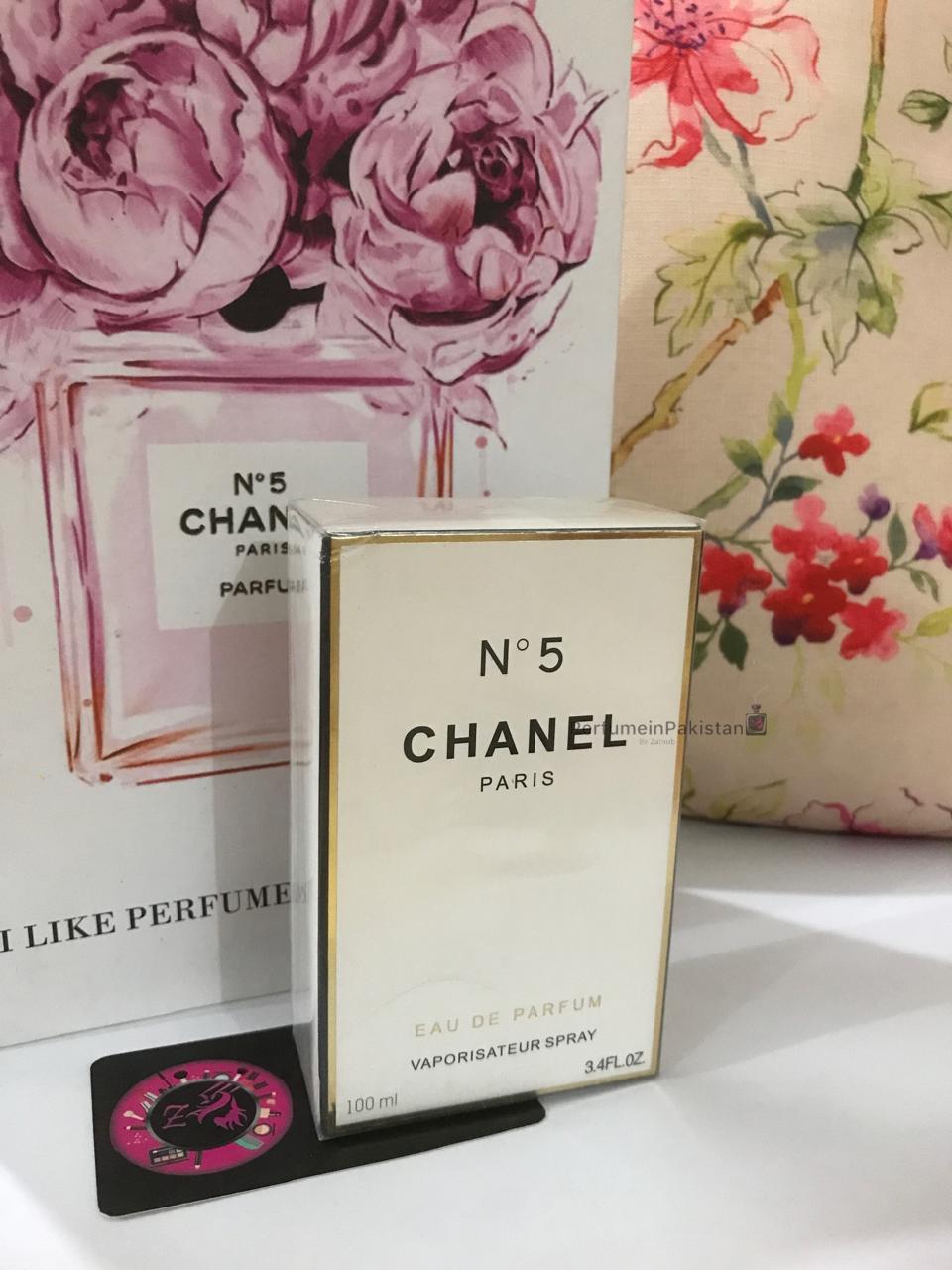 Chanel No. 5 Eau de Parfum 100ml perfume box displayed with floral Chanel-themed backdrop and PerfumeinPakistan branding card