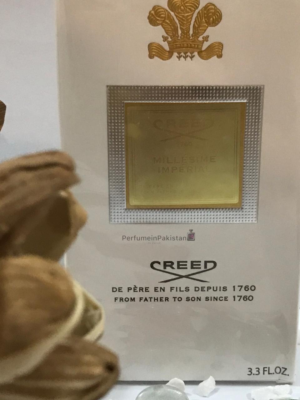 Creed Millésime Impérial Eau de Parfum 100ml perfume box displayed with decorative dried flowers and PerfumeinPakistan branding, featuring elegant white and gold packaging.
