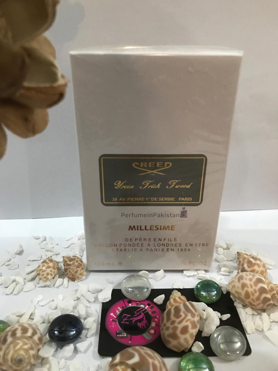 Creed Green Irish Tweed Eau de Parfum 120ml perfume box displayed with decorative seashells and glass stones, featuring elegant white and gold packaging from PerfumeinPakistan.
