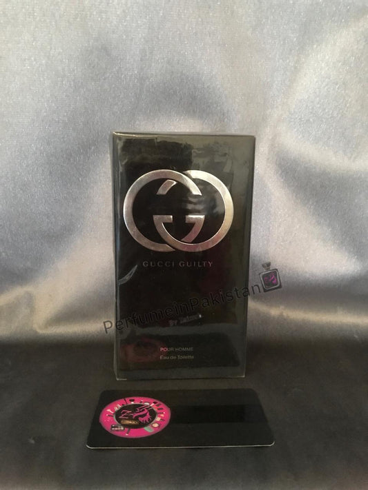 Gucci Guilty Pour Homme Eau de Toilette 100ml perfume box displayed on a dark reflective surface with silver backdrop and PerfumeinPakistan branding.